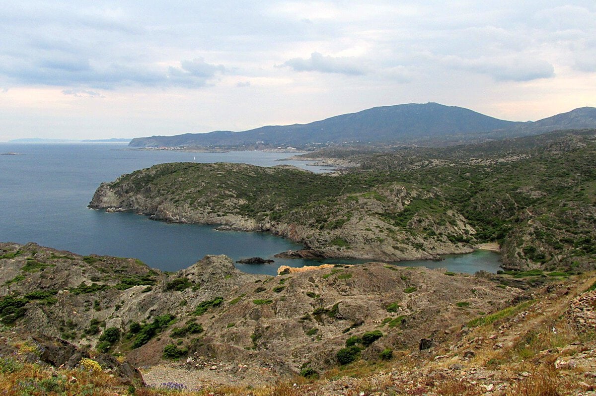 Cap de Creus burnunun kayalık kıyıları, Belleğin Azmi'nin arka planındaki manzara