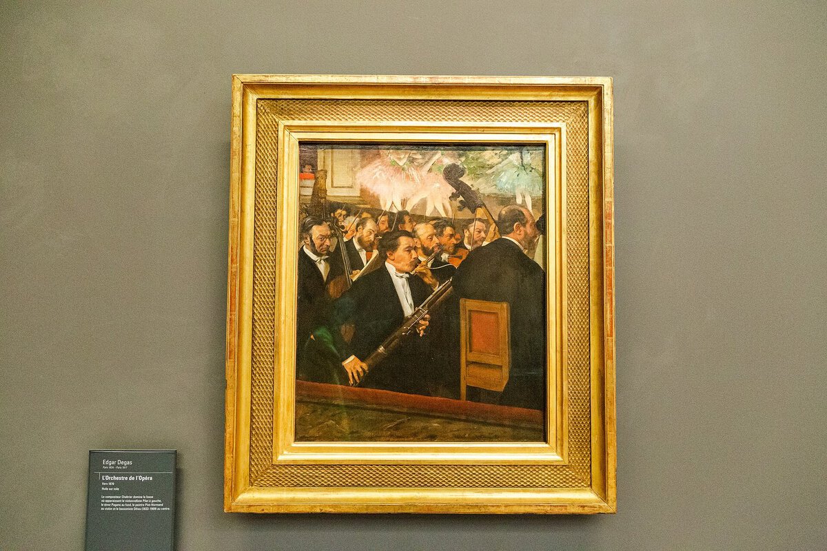 Degas'nın Opera Orkestrası tablosu: müzisyenler ve arkada balerinlerin bacakları