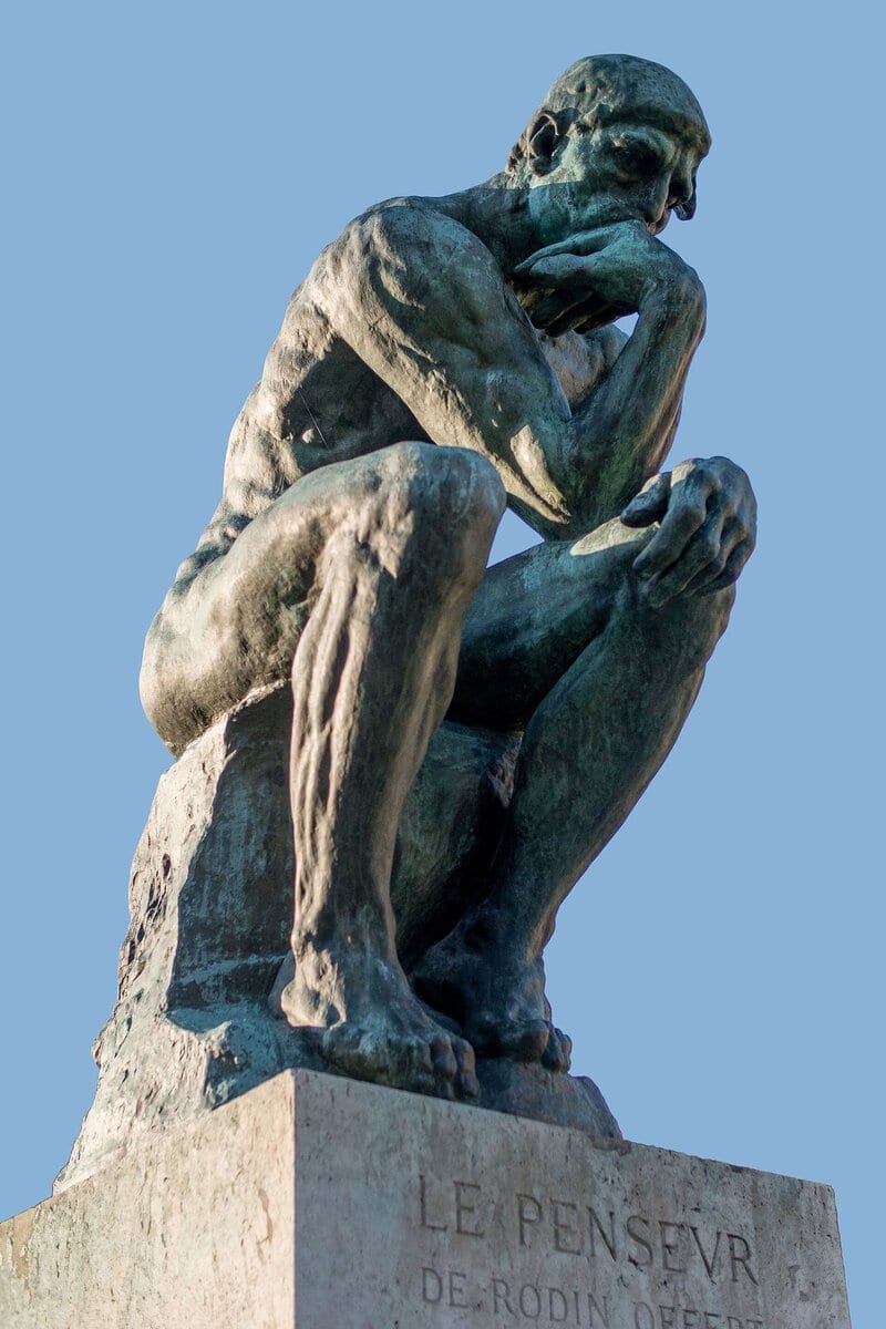 Rodin'in Düşünen Adam heykeli: çenesini eline dayamış figür